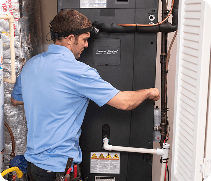 A man working on an air conditioner unit.