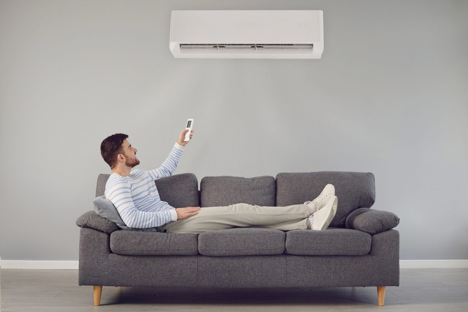 A man sitting on top of a couch holding a remote.