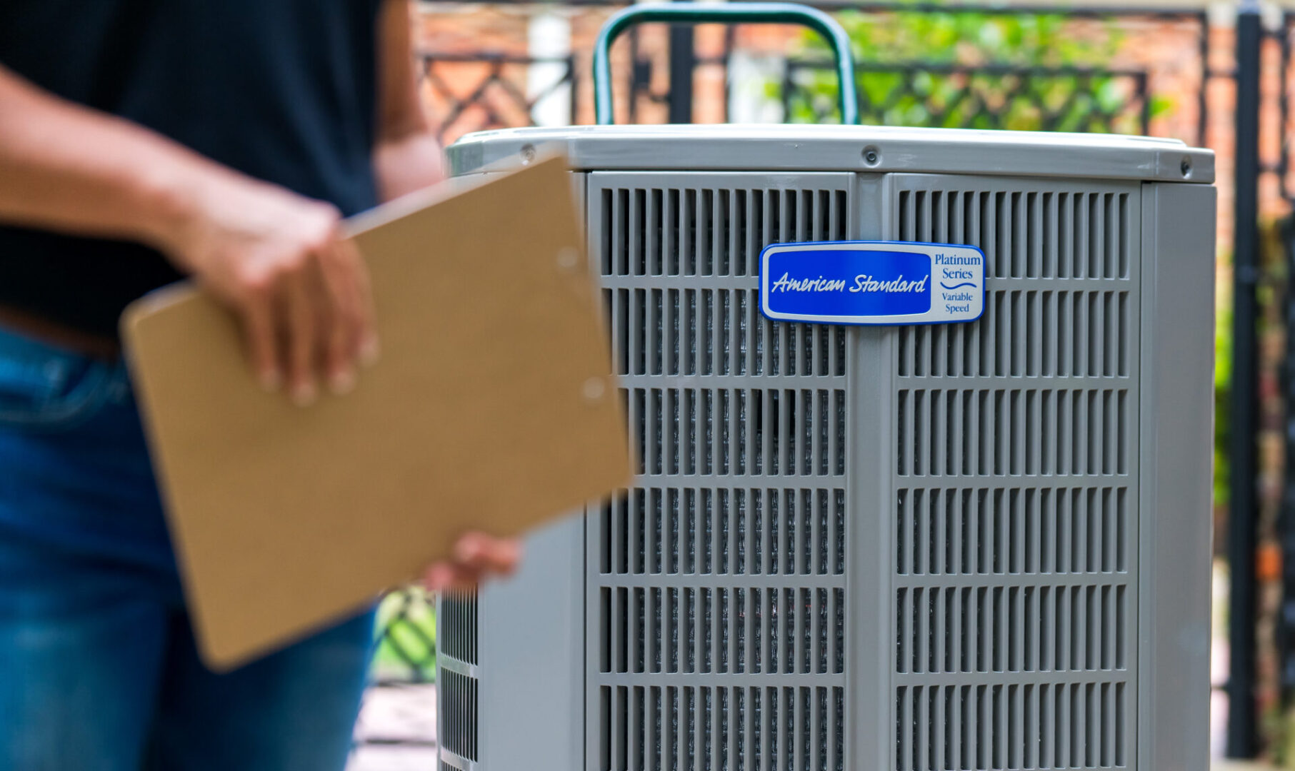 A person is holding an envelope near the air conditioner.